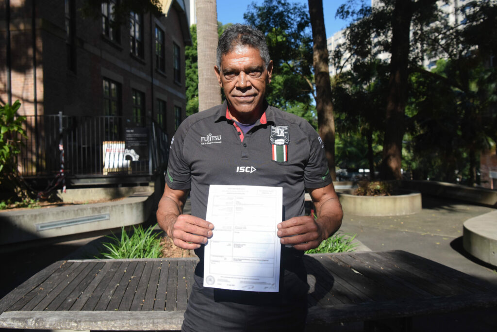 aboriginal man holding his birth certificate